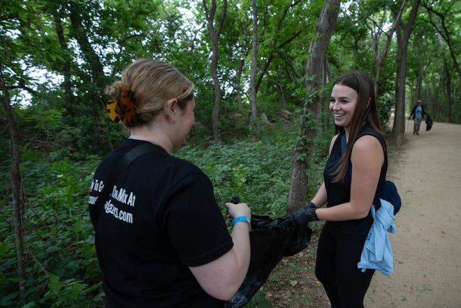 Sarah Levy and Fayth Robertson pick up trash along Butler Hike-and-Bike Trail for Earth Day Cleanup for The Trail Conservancy on Friday, April 19, 2024. Volunteers spent the day cleaning up Butler Hike-and-Bike Trail and Lady Bird Lake.